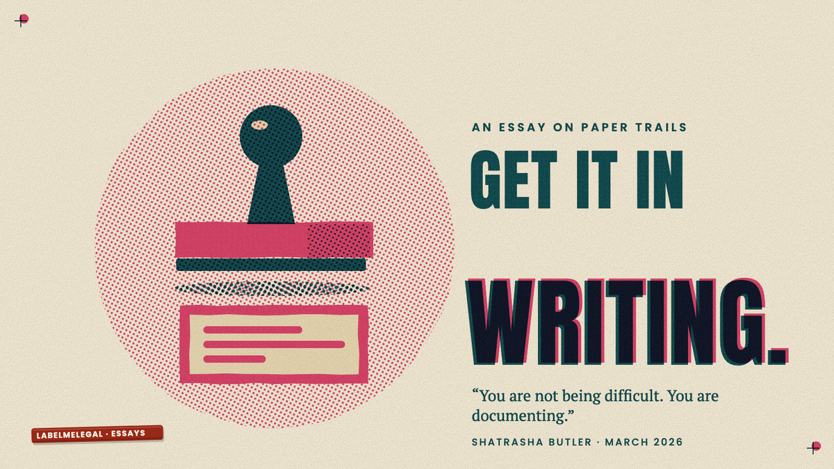 A rubber stamp lifted just above the pink box it has stamped onto the page, printed in two inks beside the words Get it in writing.