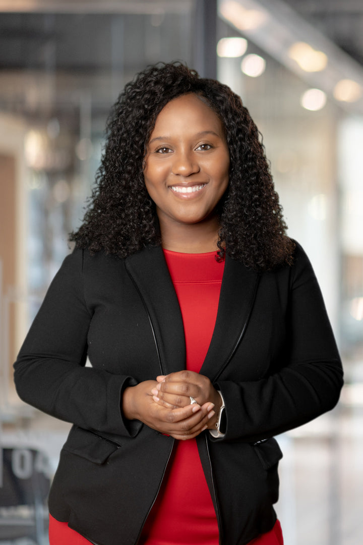 Shatrasha Butler, attorney and founder of LabelMeLegal, smiling in a black blazer and red top